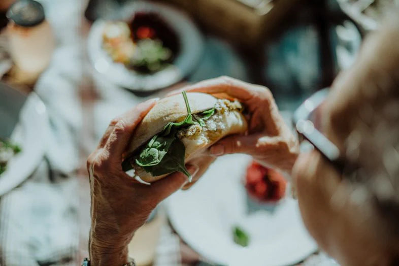 Une personne tenant entre les mains un sandwich