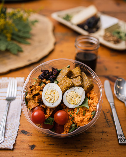 Une assiette de salade de tofus et d'épinards sur une table en bois