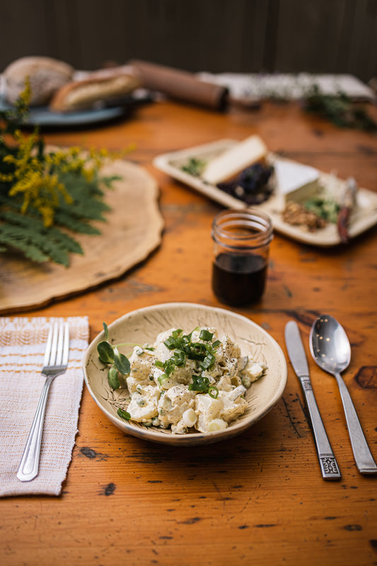 Une assiette de salade de patates à l'allemande sur une table en bois