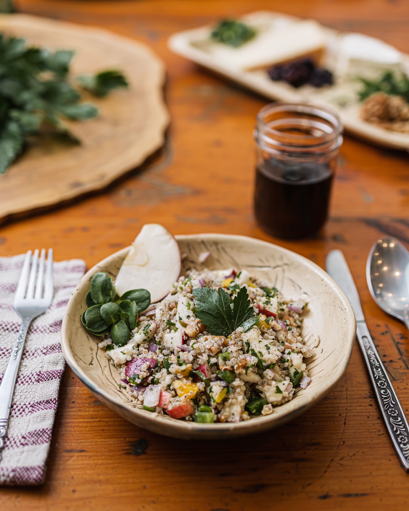  Une assiette de salade de quinoa et pommes sur une table en bois. 