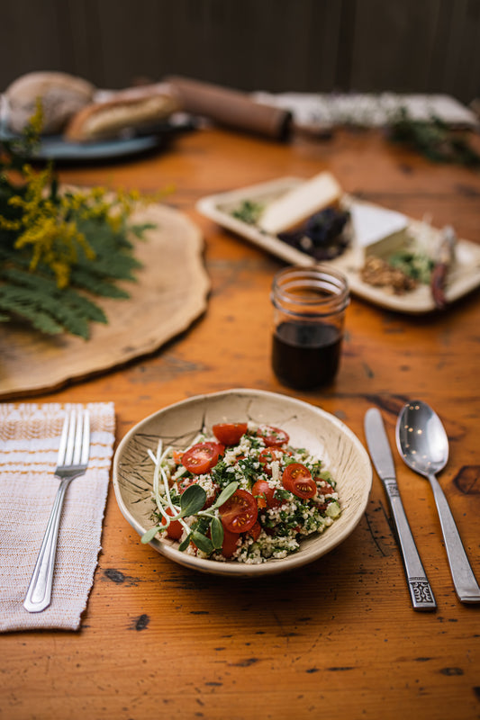 Une assiette de taboulé sur une table en bois